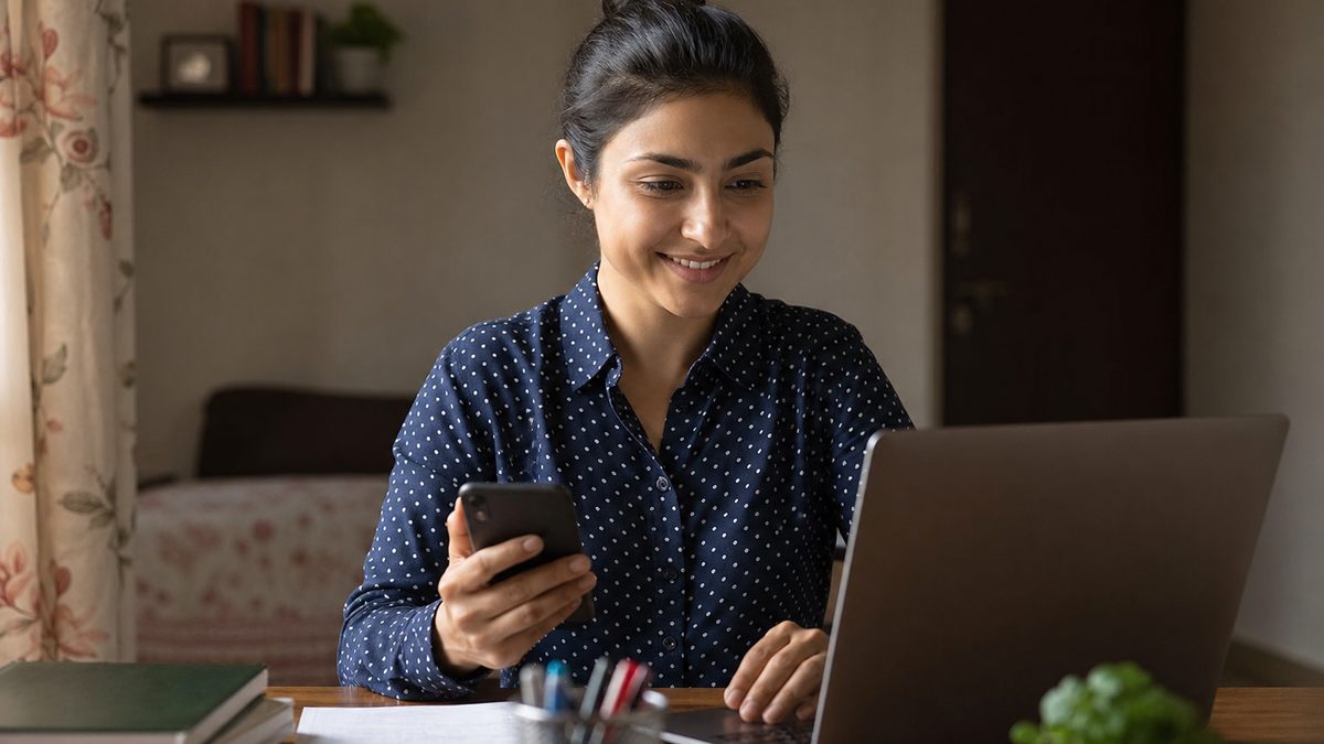 Young Indian woman using a laptop and phone to make a resume with AI se resume kaise banaye